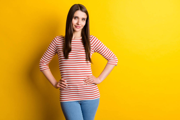 Portrait of attractive cheery content girl posing hands on hips isolated over bright yellow color background. - Foto, Imagem