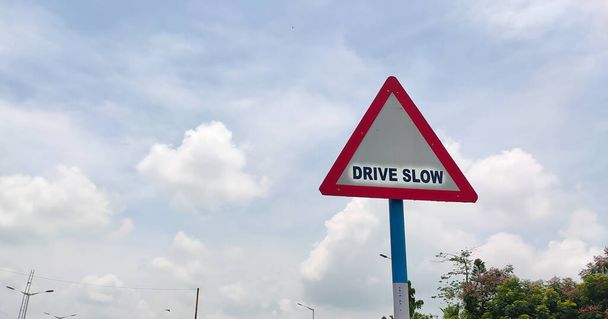 Forgalmi szabályok és jelzőtáblák közúti forgalomban lassú vezetéshez figyelmeztetésként a járművezető számára. - Fotó, kép