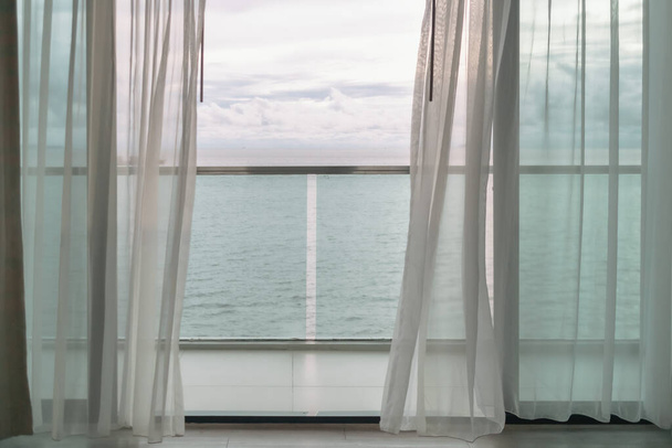 Evening time of ocean view from hotel balcony with curtains. - 写真・画像