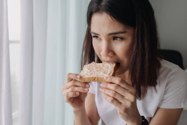Woman eat bread with sweetened condensed milk as easy breakfast. - Фото, изображение