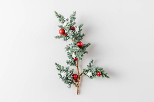 Christmas Background. Fir tree branch with decorations on white background. Flat lay. Minimal concept. Top view - Foto, Imagen