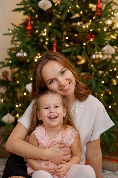 Família feliz com crianças encantadoras perto da árvore de Natal juntas em casa - Foto, Imagem