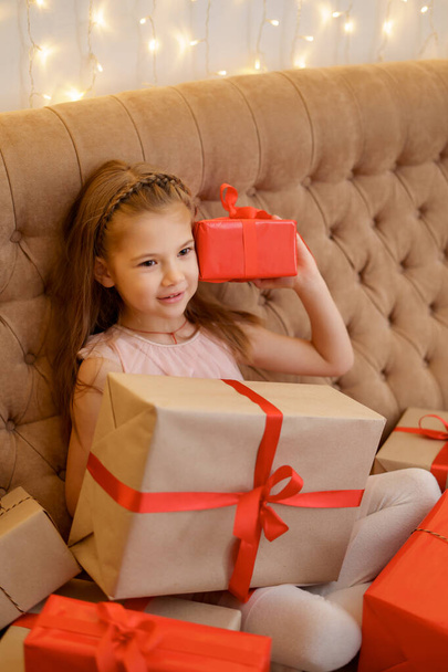 Ihana tyttö pitää lahjapakkauksia nauttien juhlan hetkestä - Valokuva, kuva