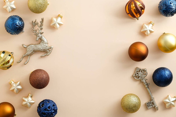 Beige Christmas background with blue, golden and bronze baubles and decorations. Flat lay, top view, copy space. - Foto, Imagem