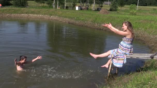 boldog lány úszni és a splash terhes anya nő a híd - Felvétel, videó