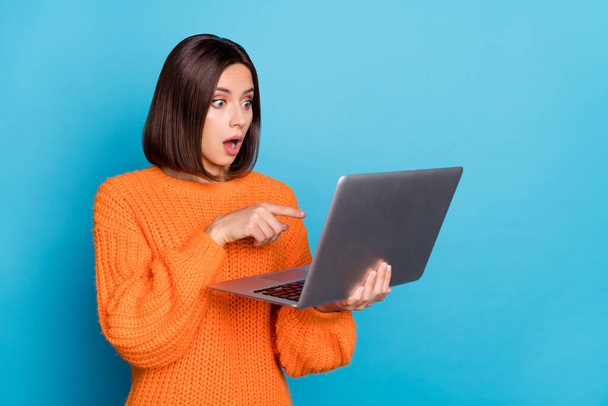 Portrait of attractive trendy amazed skilled girl using laptop pointing at screen isolated over bright blue color background. - Фото, изображение