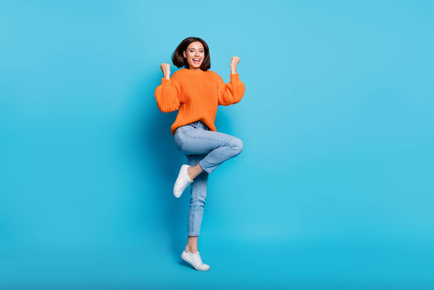 Full length body size view of attractive cheerful lucky girl jumping dancing rejoicing isolated over bright blue color background. - Fotoğraf, Görsel