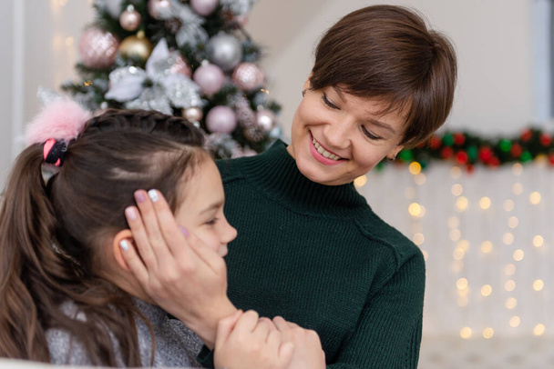 Friendship and love of mom and daughter. Family values. Mother hugs her daughter tenderly. Preparing to celebrate Christmas. Building a good relationship between mother and daughter. - Fotoğraf, Görsel