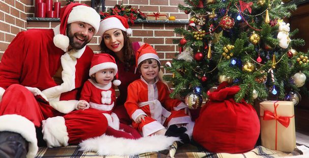 Santa Claus paar met kinderen kerstboom - Foto, afbeelding