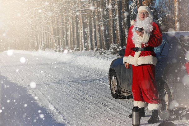 Noel Baba hediyeleri ile dışarıdan geliyor. Noel Baba sakal ve gözlük ile Kırmızı elbiseli Noel-e doğru yolda yürüyor. Noel Baba çocuklarına hediyeler getiriyor. - Fotoğraf, Görsel