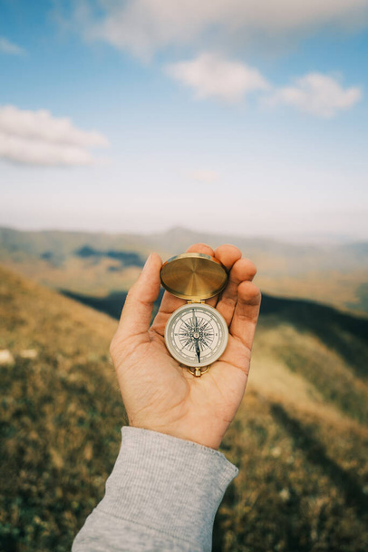 Compass in hand in the background mountain landscape. - Φωτογραφία, εικόνα