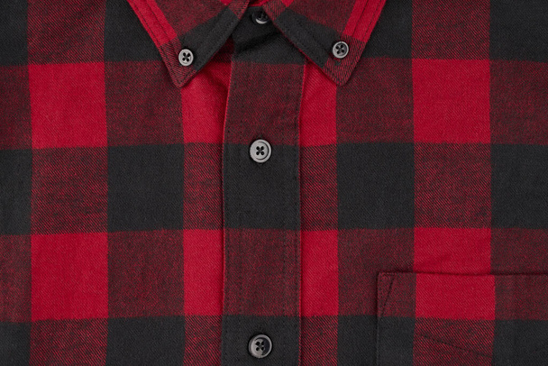 タータン柄の男性用フランネルシャツの詳細写真。センターラインとボタン付きの襟とポケットの一部を示しています。 - 写真・画像