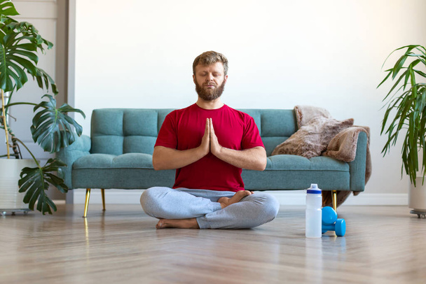 自宅でヨガの練習-中年の男性はヨガをしながら瞑想。全長写真. - 写真・画像