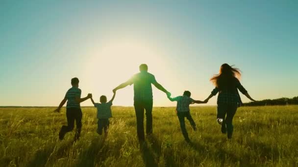 幸せな家族、両親、子供たちは公園で走ります。大きな幸せな家族の概念。日没の家族の散歩、親と子供のシルエット。お父さん息子達が一緒に歩いてる。家族旅行、夢 - 映像、動画