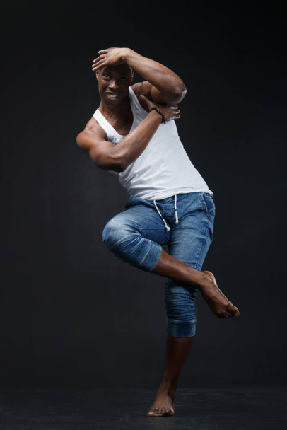 Dancing black man on a black background. - Foto, Imagen