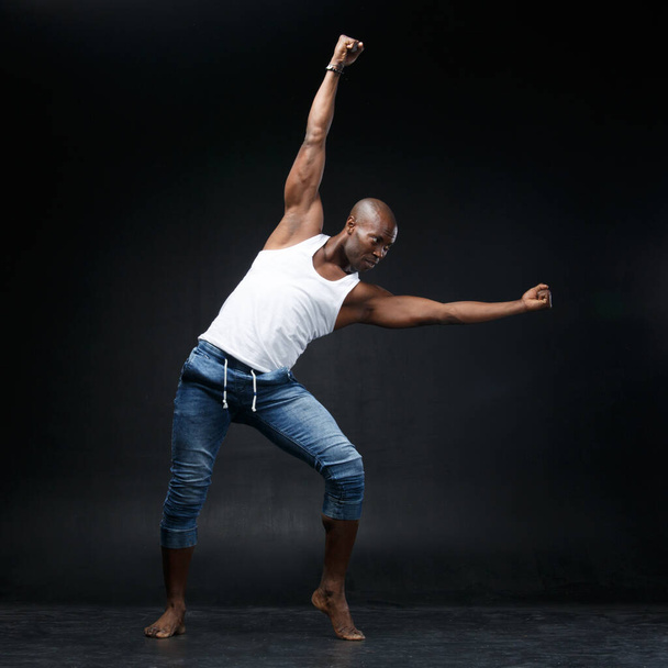 Dancing black man on a black background. - Фото, изображение