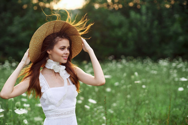 beautiful woman in a hat in a field with flowers walk - Fotografie, Obrázek