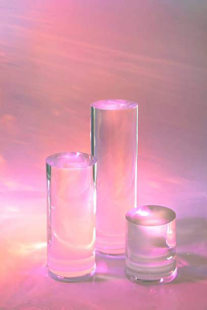 three clear glass cylinder podiums on pastel pink background  - Photo, Image