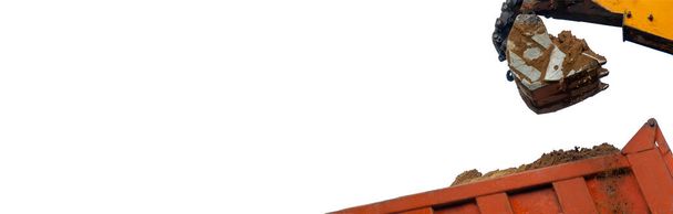 Excavadora naranja cargando tierra en un camión volquete aislado sobre fondo blanco. en el sitio de construcción. Excava en la zona agrícola. Banner con espacio de copia. Foto de alta calidad - Foto, Imagen