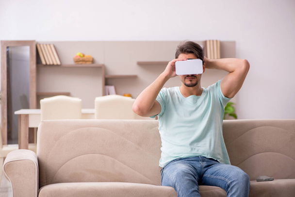 Jongeman student draagt virtuele bril thuis - Foto, afbeelding