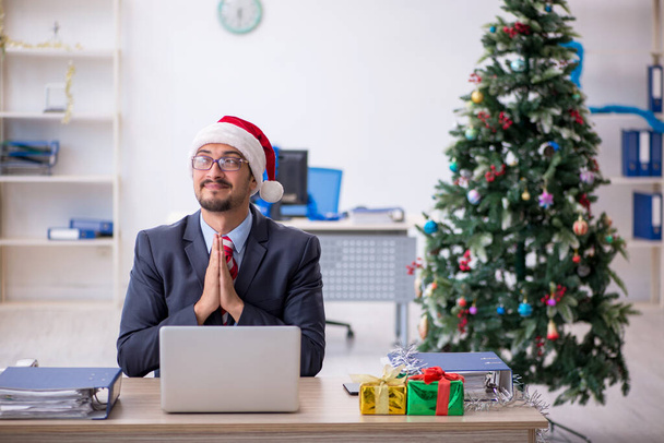 Młody pracownik świętuje Boże Narodzenie w miejscu pracy - Zdjęcie, obraz