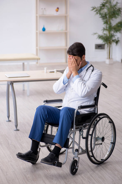 Young male doctor in wheel-chair working in the clinic - Foto, Bild