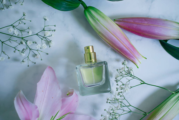 fles prachtige bloemen parfum op een granieten achtergrond - Foto, afbeelding