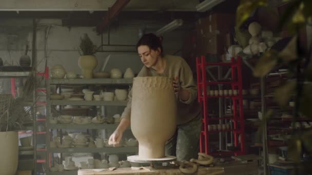 Mujer está modelando paredes de jarrón de arcilla cruda - Imágenes, Vídeo