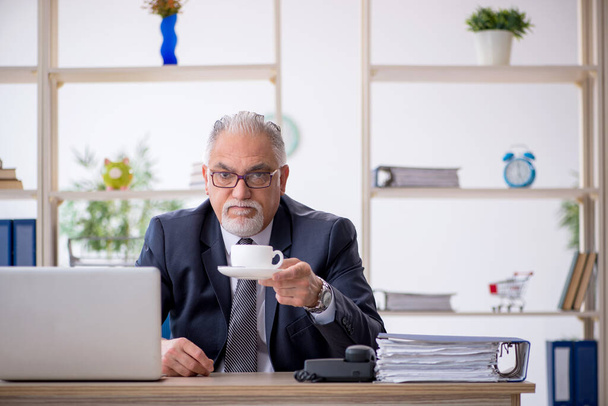 Alte männliche Angestellte trinkt Kaffee in der Pause - Foto, Bild