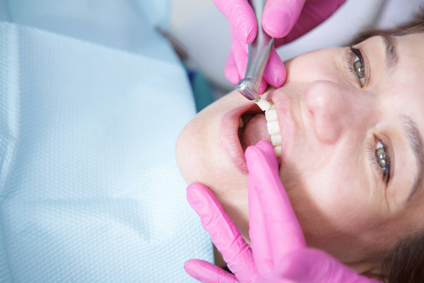 Cropped close up of a mature woman having her teeth cleaned professionally by her dentist - Фото, изображение