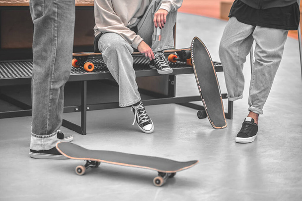 Legs of three skateboarders communicating having rest - Fotó, kép