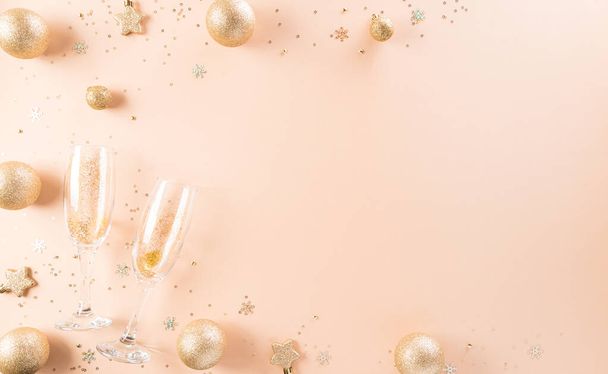 Feliz Ano Novo conceito de fundo celebração. Bola de Natal dourada, estrela e taças de champanhe em fundo pastel. - Foto, Imagem