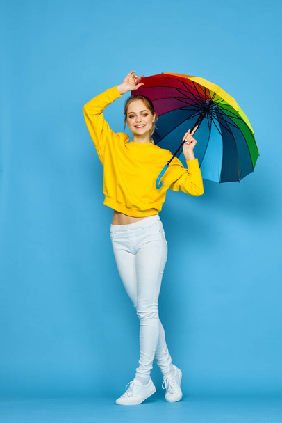 woman with multicolored umbrella in yellow sweater posing rainbow colors - Photo, image