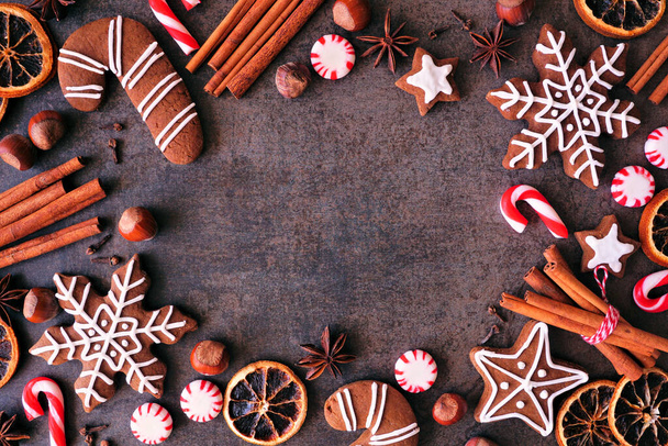 Cadre de cuisson de Noël avec biscuits, menthe poivrée et épices. Vue ci-dessus sur un fond de pierre sombre avec espace de copie. Concept de cuisson de vacances. - Photo, image