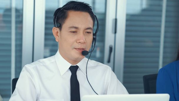 Businessman wearing headset working actively in office - Photo, Image