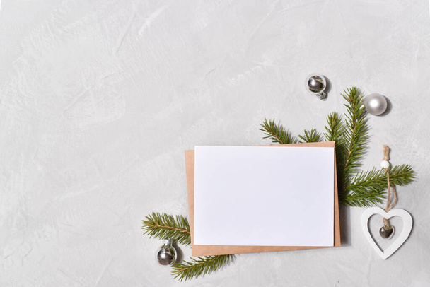 One envelope on the branches of a Christmas tree on a gray background. Top view. - Fotografie, Obrázek