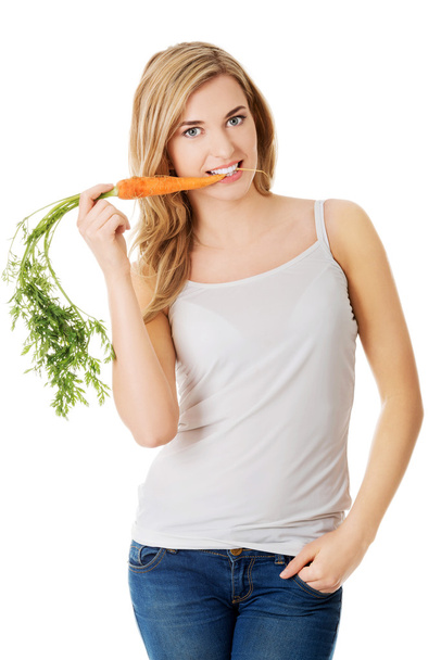 Young woman with the carrots - Фото, изображение
