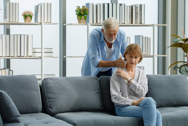Nahaufnahme von kaukasischen alten Senioren ältere Großmutter mit schmerzhaften Schulterschmerzen sitzt auf dem Sofa im Wohnzimmer zu Hause, wenn schöne Mann hilft massieren Rückenschmerzen Folter. - Foto, Bild