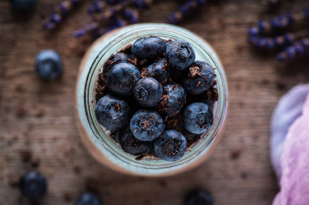 Healthy chia pudding with blueberries in jar on the rustic background. Selective focus. Shallow depth of field. - Photo, image
