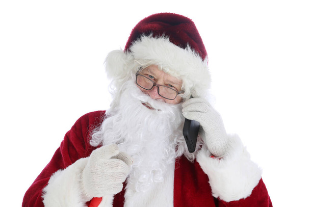 Le Père Noël utilise son téléphone cellulaire. Santa utilise son téléphone portable pour envoyer des SMS et envoyer et prendre des appels téléphoniques pendant sa saison chargée. Santa aime la technologie. Joyeux Noël. Joyeuses fêtes. - Photo, image