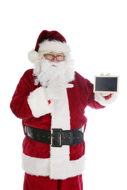 Santa Claus holds a Blank black Chalk Board. Room for text. Santa's Blank Chalk Board with room for your text or Christmas Wishes. Chalk Board for Advertising or Wish List or Naughty and Nice Names. Santa Claus pointing at black billboard. - Photo, Image