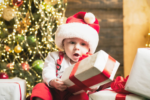 Surprised excited funny cute baby near the christmas tree. - Foto, Bild