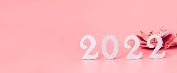 Ünnepi összetétele számok 2022 Szilveszter játékok rózsaszín pasztell háttér. Új év 2022, banner üdvözlőlap elrendezése - Fotó, kép
