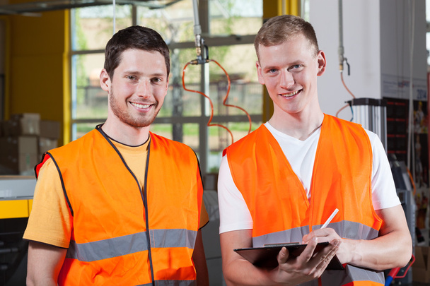 Men in orange protective vest working at factory - Zdjęcie, obraz