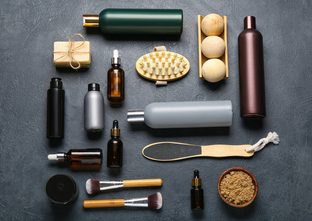 Μπουκάλια με καλλυντικά προϊόντα και προϊόντα μπάνιου σε σκούρο φόντο - Φωτογραφία, εικόνα