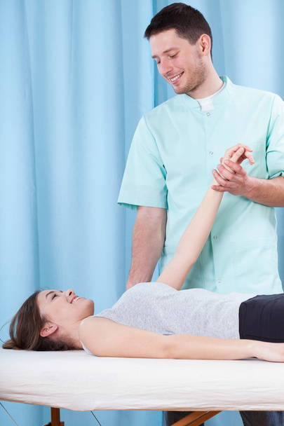 Young physiotherapist chatting up attractive patient - Foto, afbeelding