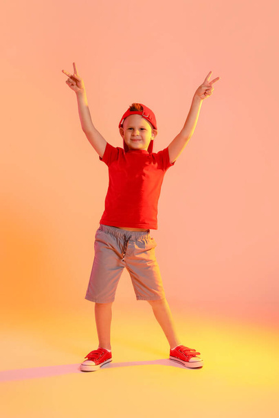 Cute little boy dancing on color background - 写真・画像