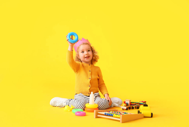 Menina bonito com brinquedos no fundo da cor - Foto, Imagem