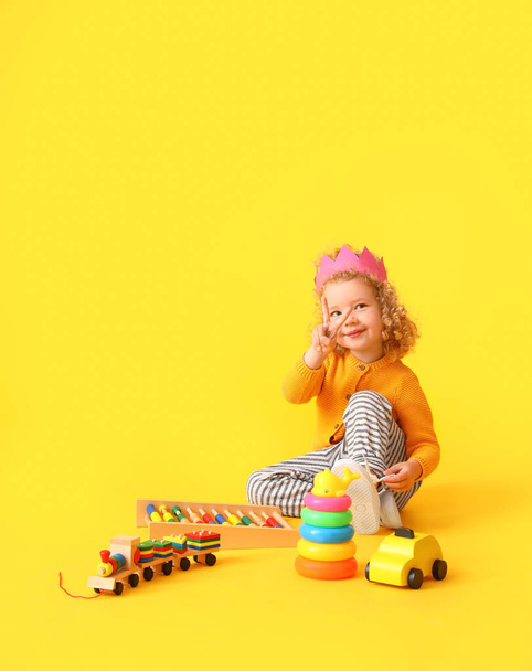 Cute baby girl with toys on color background - Photo, Image