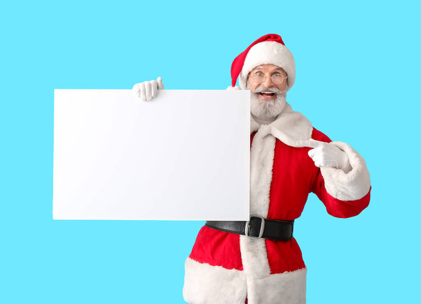 Santa Claus with blank poster on color background - Photo, Image